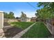 Spacious backyard with lush green grass, a detached garage, and a wood fence at 1705 W Stoll Pl, Denver, CO 80221