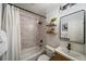 Modern bathroom featuring tiled shower-tub, stylish vanity, and decorative floating shelves at 1705 W Stoll Pl, Denver, CO 80221