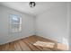 Clean, empty bedroom with hardwood floors, a bright window and a modern light fixture at 1705 W Stoll Pl, Denver, CO 80221