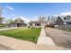 Well-maintained single-Gathering home featuring a lush front yard, and private driveway at 1705 W Stoll Pl, Denver, CO 80221