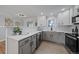 Bright kitchen featuring white cabinetry, stainless steel appliances, and elegant countertops at 1705 W Stoll Pl, Denver, CO 80221