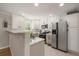 Bright kitchen with stainless steel appliances, white cabinets, tile backsplash, and neutral countertops at 1705 W Stoll Pl, Denver, CO 80221
