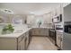 Bright kitchen with stainless steel appliances, tile backsplash, neutral countertops, and white and grey cabinets at 1705 W Stoll Pl, Denver, CO 80221