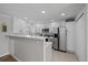Modern kitchen featuring white cabinets, stainless steel appliances, and a breakfast bar with stylish backsplash at 1705 W Stoll Pl, Denver, CO 80221