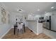 Bright kitchen features white cabinets, stainless steel appliances, and hardwood flooring with adjacent dining area at 1705 W Stoll Pl, Denver, CO 80221