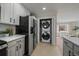 Convenient laundry area with stacked washer and dryer units plus ample cabinet space at 1705 W Stoll Pl, Denver, CO 80221