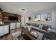 Comfortable living room features a sectional sofa, wood accent wall, and large window with natural light at 1705 W Stoll Pl, Denver, CO 80221