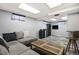 Finished basement with a sectional, TV, entertainment center, and plank flooring at 1231 W Radcliff Ave, Englewood, CO 80110