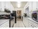Galley style kitchen features white cabinets and grey countertops at 1231 W Radcliff Ave, Englewood, CO 80110