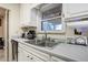 A kitchen sink is set into a counter with classic white cabinets at 1231 W Radcliff Ave, Englewood, CO 80110