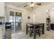 Bright kitchen features a table with stools, sliding glass door to the backyard deck, and open pantry at 1231 W Radcliff Ave, Englewood, CO 80110