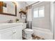 Clean bathroom with a bathtub, white vanity, and decorative shelves at 551 E Caley Dr, Centennial, CO 80121