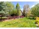 Spacious backyard with lush green grass, bordered by a charming wooden fence and colorful landscaping at 7234 S Kellerman Way, Aurora, CO 80016