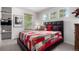 Comfortable bedroom with a patterned quilt, dark headboard, and natural light from large windows at 7234 S Kellerman Way, Aurora, CO 80016