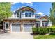 Two-story home featuring a stone-accented garage, wooden beam details, and manicured front yard landscaping at 7234 S Kellerman Way, Aurora, CO 80016
