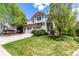 A two-story home with stone accents, two-car garage, and a beautifully landscaped front yard with mature trees at 7234 S Kellerman Way, Aurora, CO 80016