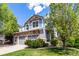 Two-story home boasts stone accents, a two-car garage, and a beautifully landscaped front yard with mature trees at 7234 S Kellerman Way, Aurora, CO 80016