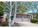 Two-story home with stone accents, two-car garage, complemented by mature landscaping, tree and concrete driveway at 7234 S Kellerman Way, Aurora, CO 80016