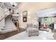 Open concept living area with staircase, featuring hardwood floors, plush carpet, and access to the dining room at 7234 S Kellerman Way, Aurora, CO 80016