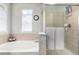Bright main bathroom showcasing a soaking tub and glass-enclosed shower at 7234 S Kellerman Way, Aurora, CO 80016