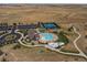 Aerial view showcasing the community pool, tennis courts, playground, and surrounding landscape at 7195 S Yantley Way, Aurora, CO 80016