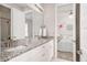 Bathroom featuring double granite vanity with white cabinets next to a decorated bedroom at 7195 S Yantley Way, Aurora, CO 80016