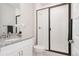 Modern bathroom featuring a walk-in shower with sleek glass doors and a granite vanity with white cabinets at 7195 S Yantley Way, Aurora, CO 80016