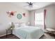 Charming bedroom with a comfy bed, crystal fan, bright window and decorative floral wall art at 7195 S Yantley Way, Aurora, CO 80016