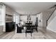 Open-concept dining room with dark wood furniture, modern lighting, and easy access to the kitchen at 7195 S Yantley Way, Aurora, CO 80016