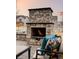 Cozy stone outdoor fireplace with comfortable seating, ideal for cool evenings and outdoor gatherings at 7195 S Yantley Way, Aurora, CO 80016