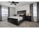 Comfortable main bedroom featuring a dark wood bed frame, a ceiling fan, and soft natural light at 7195 S Yantley Way, Aurora, CO 80016