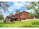 Back exterior of the home showcasing a large lawn, stairs to the deck, and partial fencing at 8662 Kim Ct, Parker, CO 80134