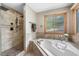 Well-appointed bathroom featuring a soaking tub, a separate shower, and a large window offering natural light at 8662 Kim Ct, Parker, CO 80134