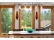Bright dining area with wood-framed windows and nature views, accented by a stylish light fixture and decorative bowl at 8662 Kim Ct, Parker, CO 80134