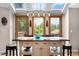 Bright kitchen dining area with skylights, wooden table, and stylish lighting, perfect for casual meals at 8662 Kim Ct, Parker, CO 80134