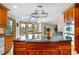Open-concept kitchen with a large island, granite countertops, custom wood cabinets, and natural light from large windows at 8662 Kim Ct, Parker, CO 80134