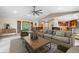 Bright living room with a large sectional sofa, wooden coffee table, and a stone fireplace, adjacent to an open kitchen at 8662 Kim Ct, Parker, CO 80134