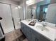 Bathroom featuring a double vanity, shower with glass enclosure, and modern fixtures and lighting at 3074 Distant Rock Ave, Castle Rock, CO 80109