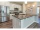 Granite kitchen island complements the stainless steel appliances and white cabinets at 3074 Distant Rock Ave, Castle Rock, CO 80109