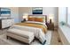 Well-lit main bedroom with an upholstered bed, bench, and coordinated modern decor in neutral colors at 3074 Distant Rock Ave, Castle Rock, CO 80109