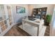 Bright home office with a large white desk, wood floors, and natural light from the glass paneled door at 3074 Distant Rock Ave, Castle Rock, CO 80109