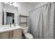 Well-lit bathroom features a modern vanity, shelving, and a shower with a striped curtain at 2922 W 26Th Ave # 4, Denver, CO 80211