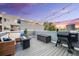 Outdoor living with deck featuring a fire pit, grill, and string lights against a colorful sky at 2922 W 26Th Ave # 4, Denver, CO 80211