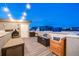 Inviting rooftop deck with a fire pit and outdoor seating, illuminated by soft string lights at 2922 W 26Th Ave # 4, Denver, CO 80211