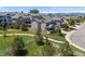 Wide aerial shot shows a neighborhood with manicured lawns, mature trees, and walking paths at 3554 E 143Rd Pl, Thornton, CO 80602
