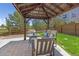 Backyard patio with gazebo and outdoor seating next to a green lawn and fence at 3554 E 143Rd Pl, Thornton, CO 80602