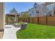Expansive backyard with green lawn, gazebo, stone fire pit, and wood fence at 3554 E 143Rd Pl, Thornton, CO 80602