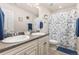 Bright bathroom features a double sink vanity and shower with a floral curtain at 3554 E 143Rd Pl, Thornton, CO 80602
