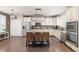 Spacious kitchen featuring a large center island with seating, granite countertops, and stainless steel appliances at 3554 E 143Rd Pl, Thornton, CO 80602