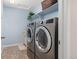 Well-lit laundry room featuring front loading washer and dryer set and storage at 3554 E 143Rd Pl, Thornton, CO 80602